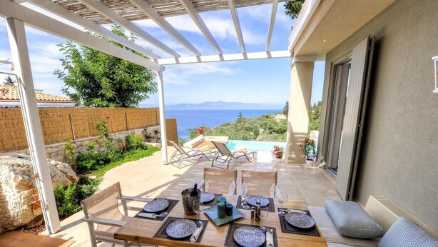An outdoor dining area with a view of the sea, a pool, and a pergola. - Apeiron I Villa - Instaworthy Views Ace Location (Paxos)