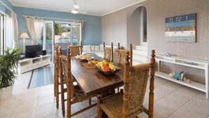 A dining area with a wooden table, wicker chairs, and a fruit basket. - Danai Villa - Charming Escape With Oceanside Views (Paxos)