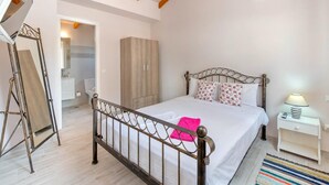 A bedroom with a bed, a wardrobe, a bedside table, and a lamp. - Angelina Villa - Four Bedroom Traditional Paxos Villa (Paxos)