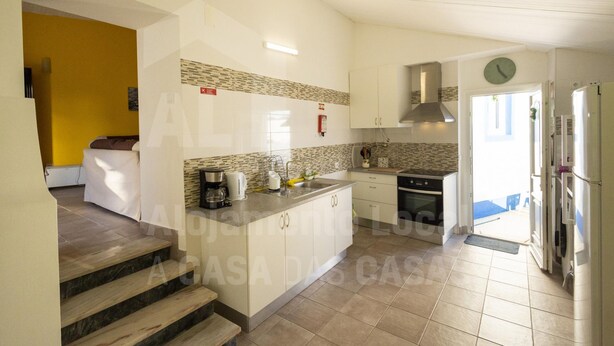 A modern kitchen with white cabinets, a built-in stove, and a microwave. - Casa Aconchego by Acasadascasas (Mafra)