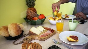 A breakfast table with bread, cheese, ham, and a pineapple. - Casa Aconchego by Acasadascasas (Mafra)