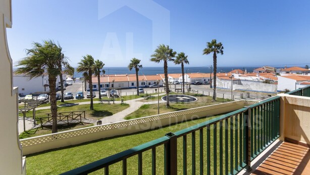 A balcony with a view of a coastal town, palm trees, and a roundabout. - Kiko s House by Acasadascasas (Mafra)