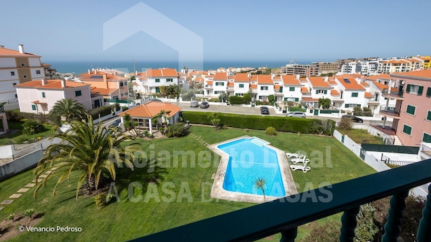 A residential area with a swimming pool, palm trees, and a view of the sea. - Ocean Apartment by Acasadascasas (Mafra)