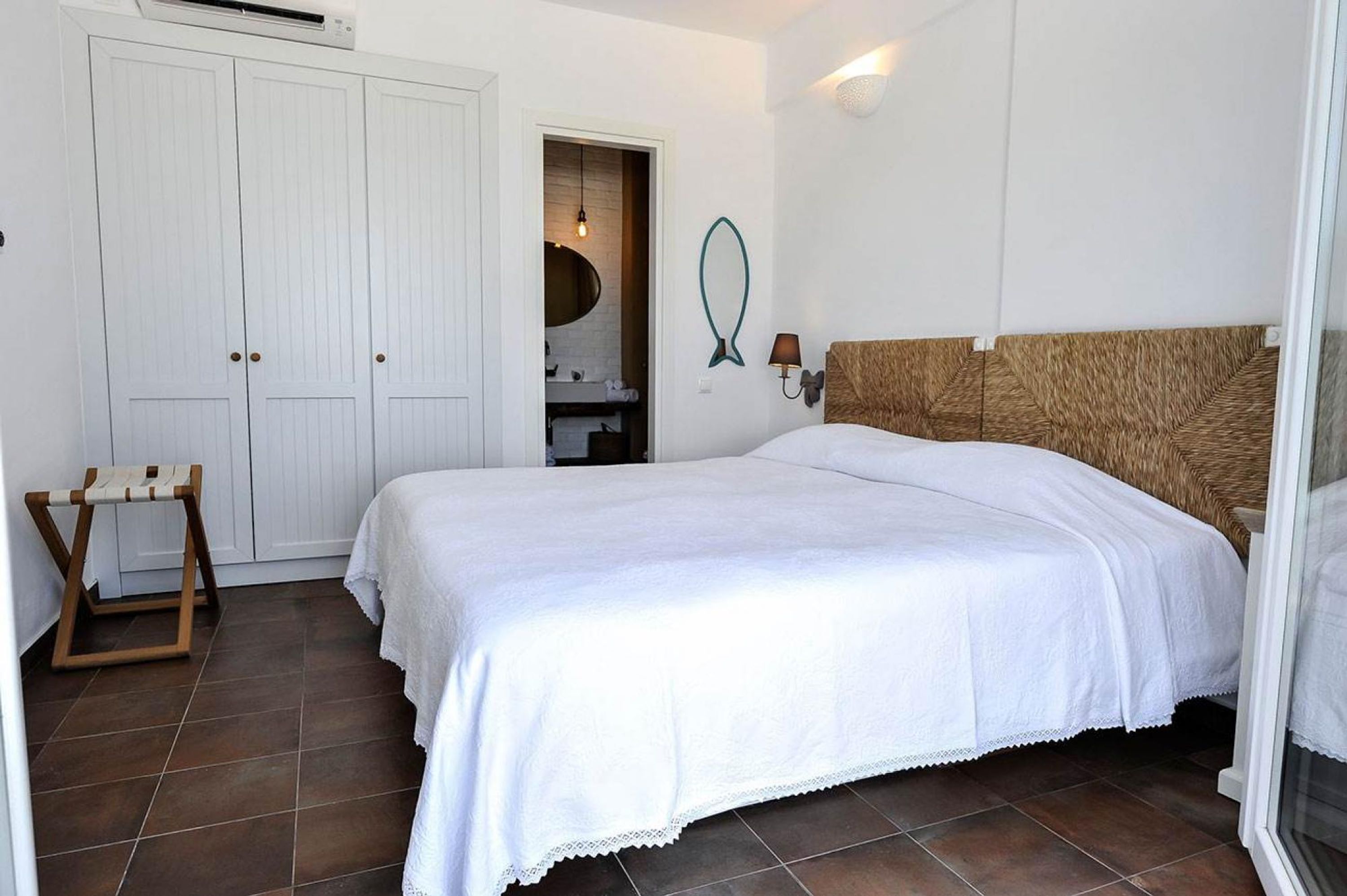 Une chambre à coucher avec un grand lit, une armoire, une petite table et un miroir.