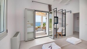 Ein modernes Schlafzimmer mit einer Schiebetür zum Balkon mit Meerblick.