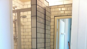 A compact bathroom with a glass-enclosed shower, a sink, and a washing machine. - Face mer Plage à 2m Studio 4 Personnes (Sète)