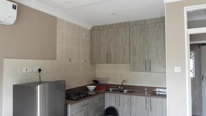 A compact kitchen with a built-in refrigerator, a stove, and a sink.