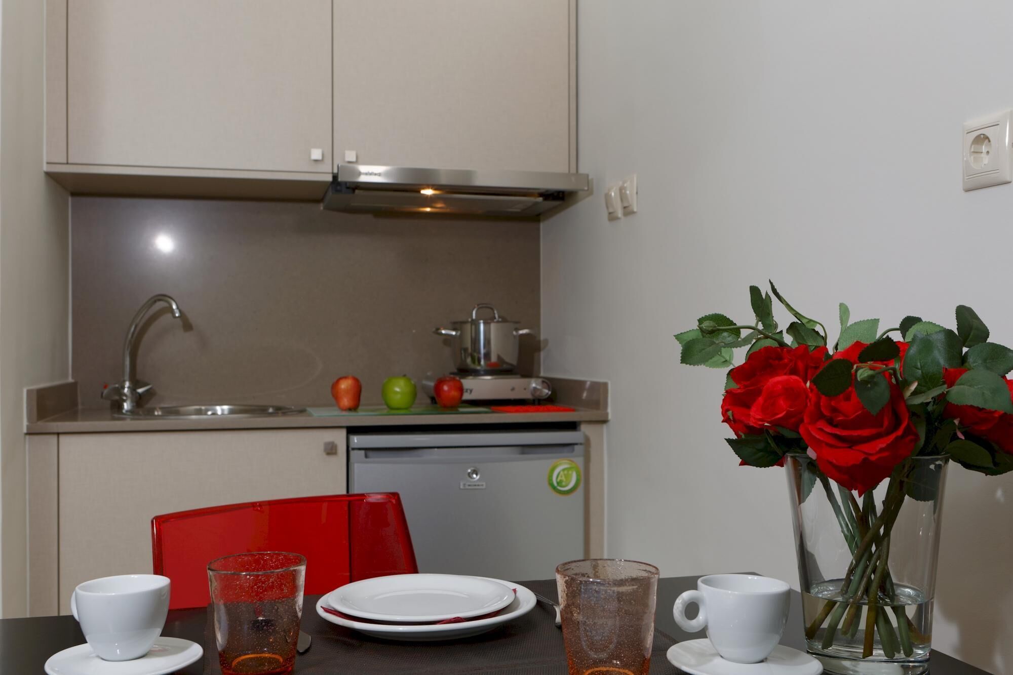 Une cuisine moderne équipée d’un évier, d’une cuisinière et d’un coin repas avec une table mise pour deux personnes.