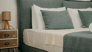 A bed with a green headboard, white bedding, and a lamp on a bedside table. - Lenko Bianco Studio by Estia (Corfu)