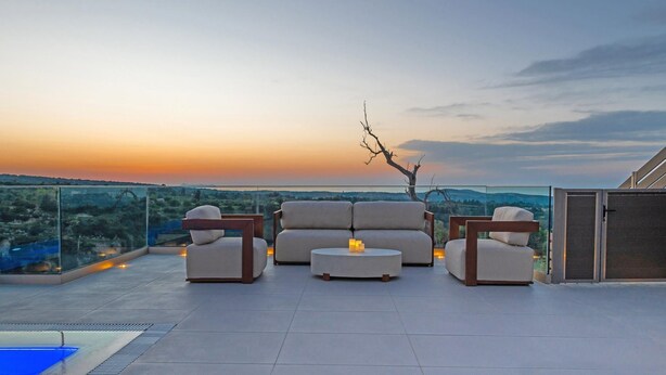 A rooftop terrace with a sofa set, a small table, and a pool. - Dim Luxury Villa - With Private Pool (Mylopotamos)