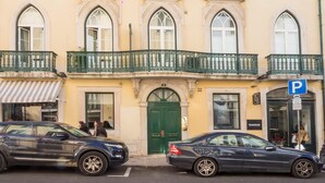 A multi-story building with arched windows and a green balcony railing. - Nomad s Chiado Lisbon - The Ivens Signature (Lisbon)