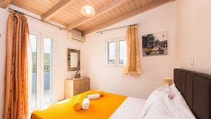 A hotel room with a bed, curtains, a window, a painting, and a dresser. - Blue Villa 1 - With Private Pool (Mylopotamos)