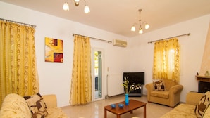 A living room with patterned sofas, a coffee table, and a TV. - Blue Villa 1 - With Private Pool (Mylopotamos)