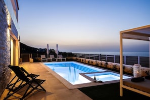 A rooftop pool with lounge chairs and a view of the sea. - Dodici Luxury Villa - With Heated Pool (Mylopotamos)