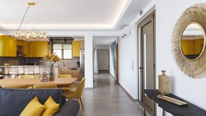 Un salon moderne avec un canapé, une table à manger et une cuisine en arrière-plan.