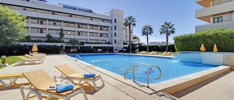 A pool area with lounge chairs and a swimming pool.