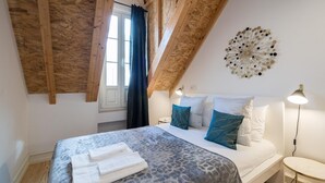 Une chambre à coucher avec un lit, des oreillers, une table de chevet, une lampe et un élément décoratif mural.
