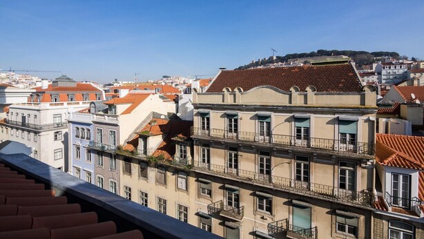 Une vue sur un paysage urbain avec des bâtiments dotés de toits recouverts de tuiles rouges et de balcons.