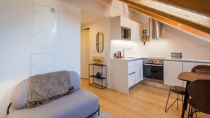 Un espace de vie compact comprenant un coin cuisine, un canapé et un coin repas.