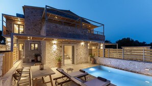 A two-story stone house with a swimming pool, outdoor seating, and a staircase leading to the upper level. - Armonia II Villa in Paxi (Paxos)