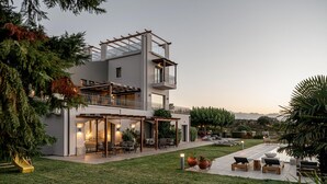 Uma casa moderna de dois andares com varanda coberta, área de estar ao ar livre e vista para as montanhas.