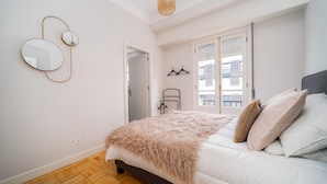A bedroom with a bed, a mirror, and a window with shutters. - Nomad s By Sta Catarina Flats - 3bed Moments (Porto)