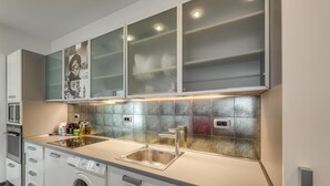 A modern kitchen with a built-in washing machine, a stainless steel sink, and a microwave. - Top Centre Apartment Next to Vitosha Boulevard (Sofia)