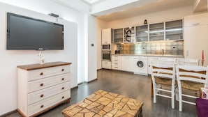 A modern kitchen with a flat-screen TV, built-in oven, microwave, and washing machine. - Top Centre Apartment Next to Vitosha Boulevard (Sofia)