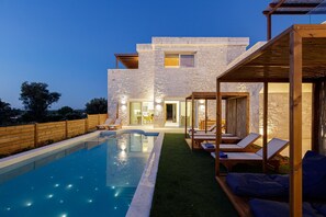 A modern house with a swimming pool, outdoor seating, and a stone facade. - Mandana Villa - With Heated Pool Jacuzzi (Rethymno)