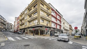 A multi-story building with a corner entrance, a pedestrian crossing, and a 'no entry' sign. - Nomad s Family - 2bdr Sunny Firmeza (Porto)