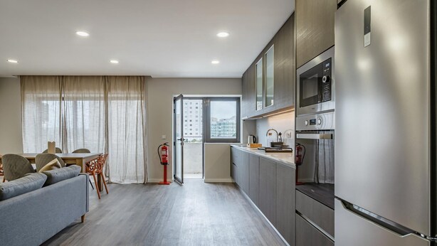 Een modern appartement met een woonkamer, keuken en balkon.