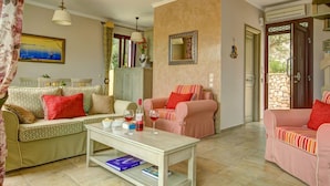 A cozy living room with two sofas, a coffee table, and a bookshelf. - Kalliope Villa - Classic Modern With a Splash of Glam (Paxos)