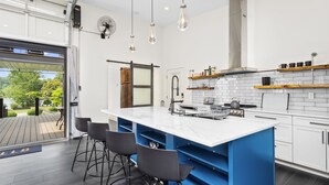 Una cocina moderna con una isla grande, taburetes de bar y vistas al exterior.