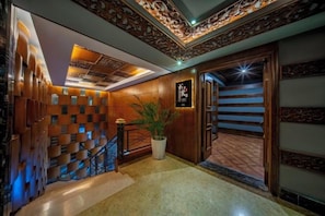 A hotel lobby with a wooden staircase, a potted plant, and a decorative ceiling. - Kehuayuan Hotel (Chengdu)