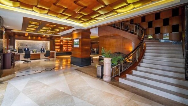 Eine moderne Lobby mit Empfangstresen, einer Treppe und einem Marmorboden.