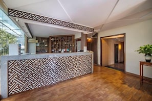 A reception area with a patterned counter, wooden flooring, and a view of the interior.