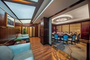 A modern hotel room with a dining area, a large window, and a chandelier. - Kehuayuan Hotel (Chengdu)
