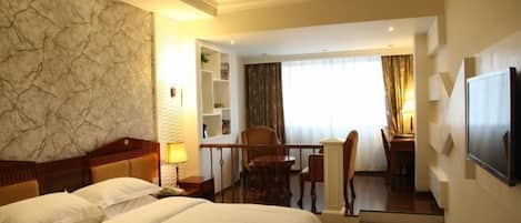 Habitación de hotel con una cama grande, un escritorio con silla, un televisor montado en la pared y un balcón con vistas.