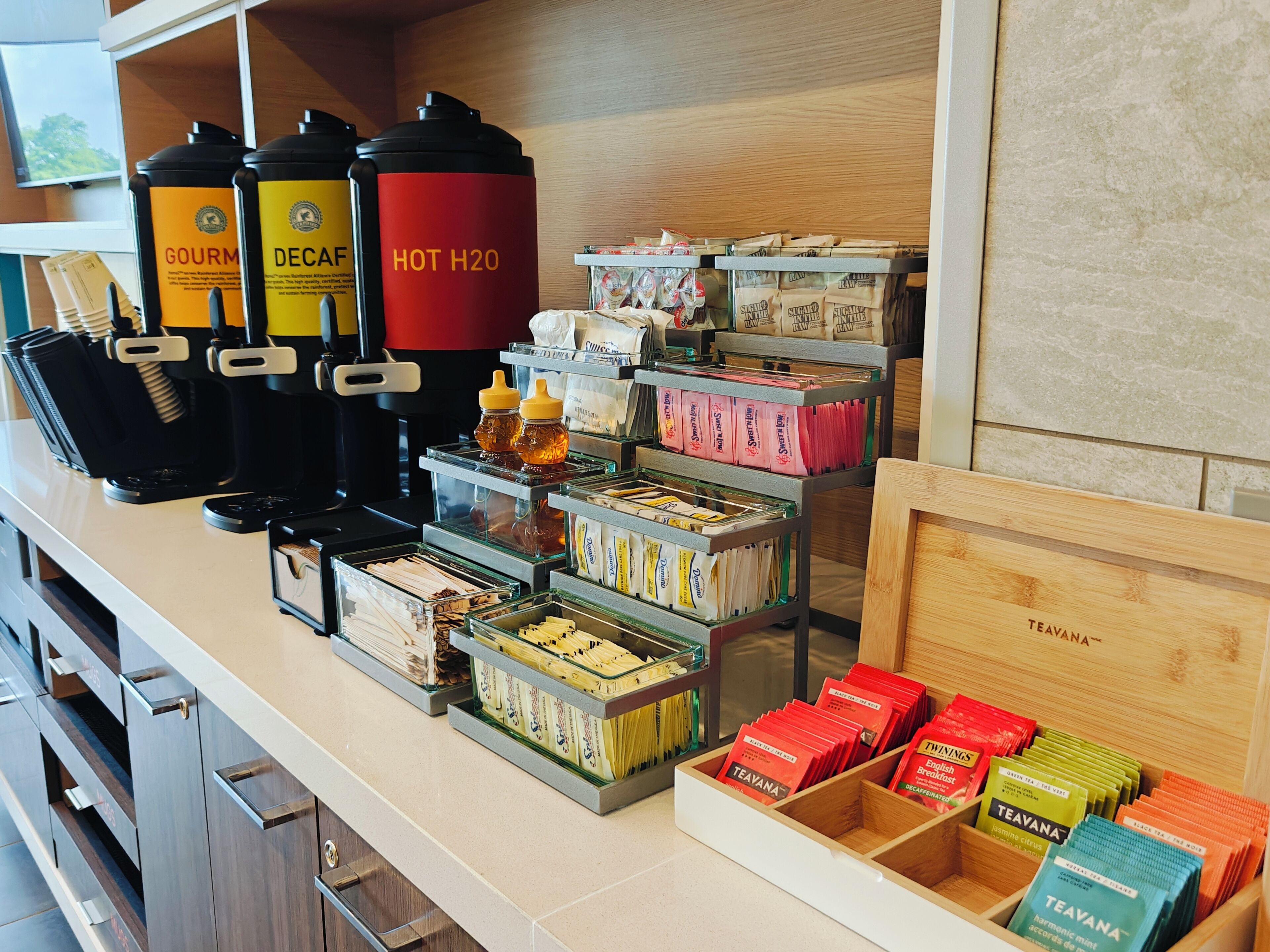 Un espace dédié au café, équipé de machines à expresso, de sucre, de miel et de sachets de thé.