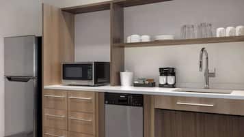 A modern kitchen with a stainless steel refrigerator, a microwave, a dishwasher, and a sink with a faucet.