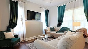 A living room with a sofa, armchairs, a coffee table, and a flat-screen TV mounted on a wall. - NEW! Classy 3BR Home ~ 5 min to DT + Eateries (Knoxville)