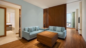 Una sala de estar moderna con dos sofás azul claro, una mesa de centro de madera y un gran panel de pared de madera.