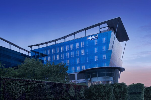 A modern hotel with a blue facade, large windows, and a curved glass entrance. - Fairfield by Marriott Agra (Agra)