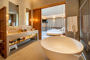 Ein modernes Badezimmer mit einer großen Badewanne, einem Waschtisch mit Spiegel und einer Duschkabine.