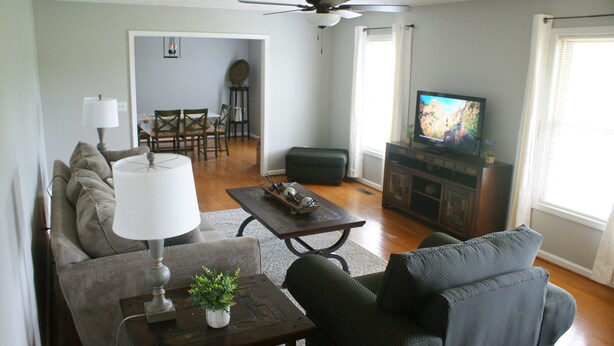 A living room with a sofa, a coffee table, a lamp, a television, and a fireplace.