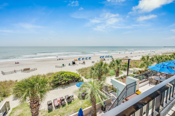 Enjoy ocean views from the balcony with outdoor seating and umbrellas.