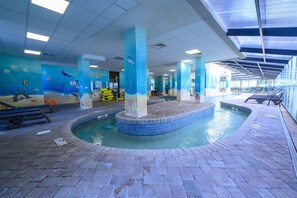Relax by the pool surrounded by marine-themed murals and a blue mosaic border.
