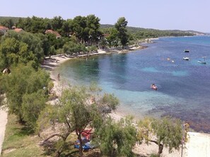 Eine Küstenlandschaft mit klarem Wasser, einem Strand und einigen Booten.