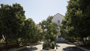 Un cortile pavimentato con alberi e un edificio sullo sfondo.