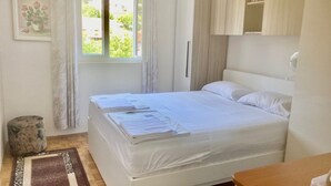 A bedroom with a bed, a window, a bedside table, and a wardrobe. - Apartment Villa Mimmi - Three Bedroom Duplex Apartment with Balcony (Sutivan)